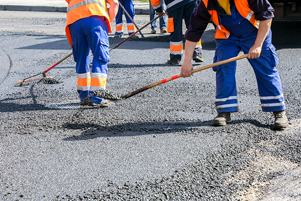 Workers repairing road surface