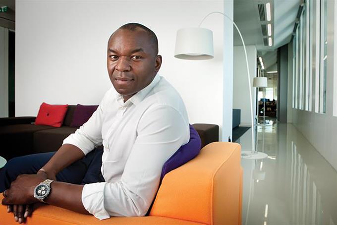 UM CSO Enyi Nwosu sits on an orange couch in an office