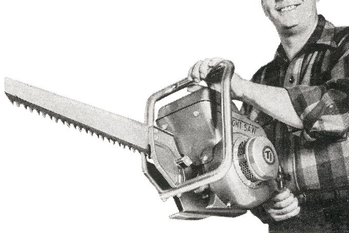 A black and white picture of a man holding an old-fashioned machine saw