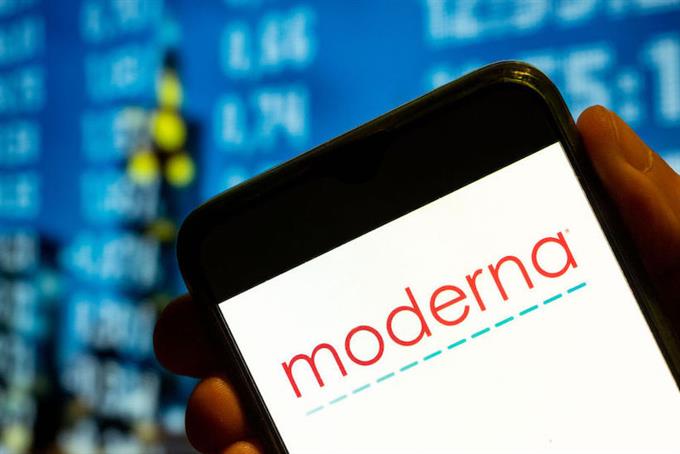Hand holding smart phone displaying Moderna logo