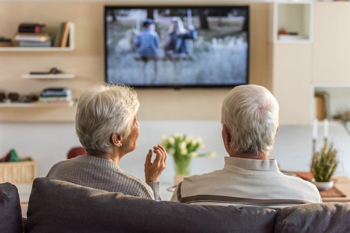 Two senior citizens watching TV