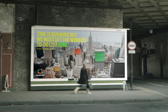 Pedestrian walks past steet-level Project Everyone billboard