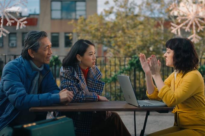 People sitting at a park table in the winter using a Microsoft laptop