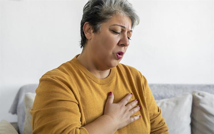 Middle-aged woman clutching her chest