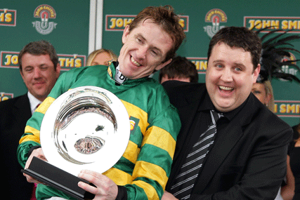 Peter Kay presents Tony McCoy with the winner's trophy at the John Smith's Grand National