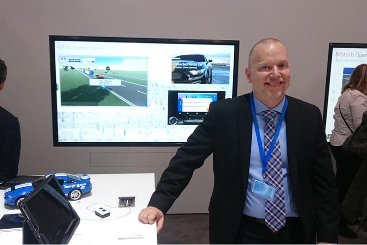 Jason Collins standing in front of a demo of Nokia's connected car rental service