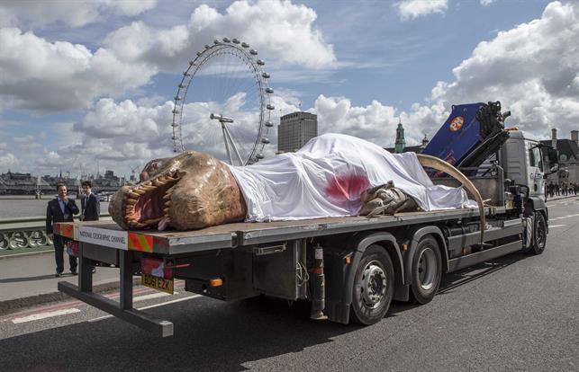 The dinosaur was laid out and strapped to a flatbed truck, partially covered by blood-soaked sheets