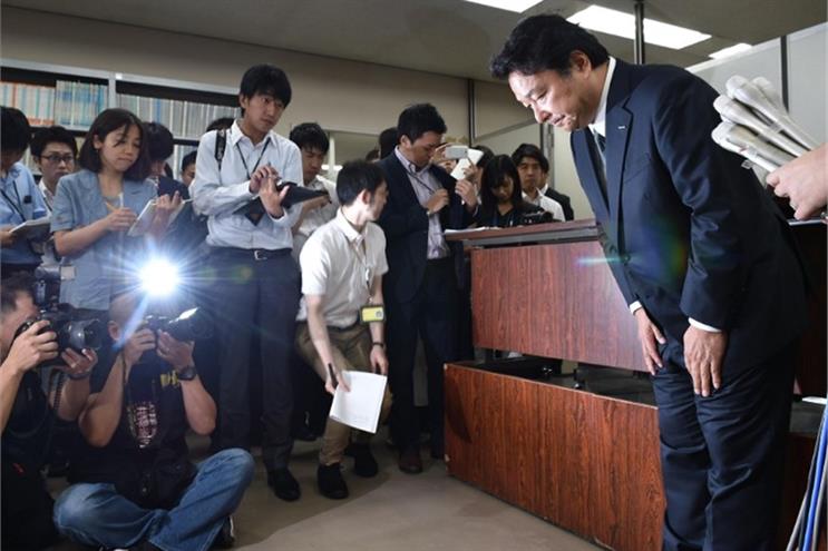 Dentsu president Toshihiro Yamamoto bows at a press conference in Tokyo (AFP)