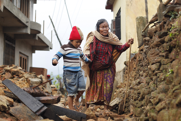 Jagot Kumari Rana, 79, is led through the rubble of collapsed homes by her grandson Sogat Rana, 7, in Paslang village near the epicenter of Saturday's massive earthquake in the Gorkha District of Nepal (pic credit: Wally Santana/AP/Press Association 