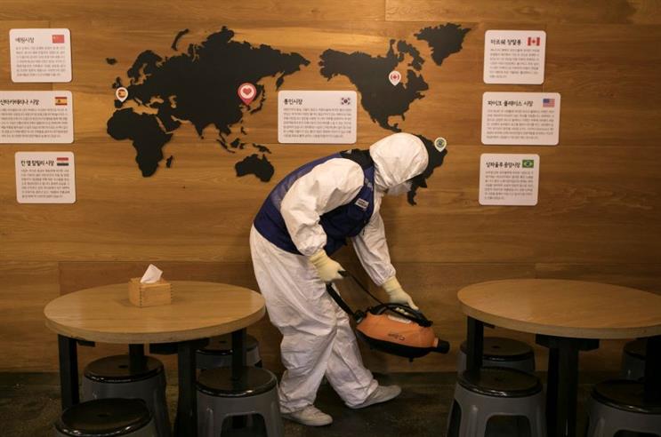 A disinfection worker in protective gear sterilizes a restaurant in Seoul, South Korea. (Photo credit: Getty Images)