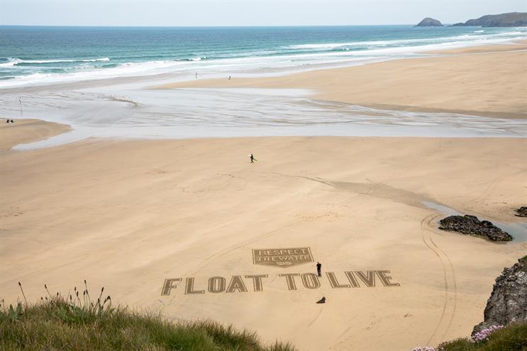 An aerial photo showing the Respect the Water campaign's Float to Live message, created by a local sand artist at Perranporth beach, Cornwall
