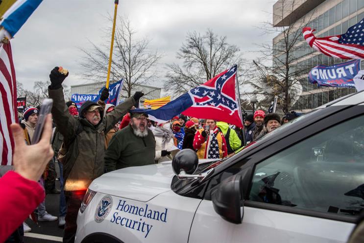 Rioters outside the Capitol building carried Confederate flags. (Source: Getty Images).