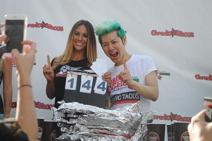 Takeru Kobayashi celebrates his 2015 win, consuming 140 tacos in 10 minutes. The initial tally was 144 but was decreased due to leftover table scraps.