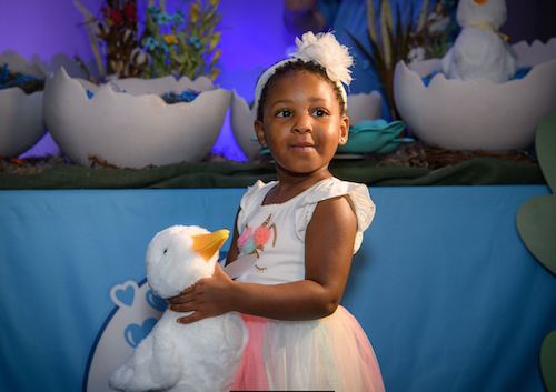 little girl holding a My Special Aflac duck toy