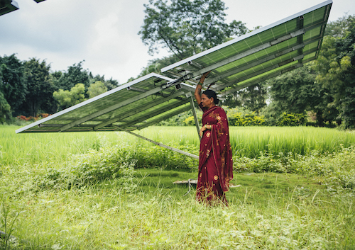 woman standing beneath a solar panel