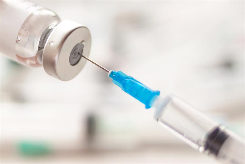 Syringe extracting COVID-19 vaccine from vial
