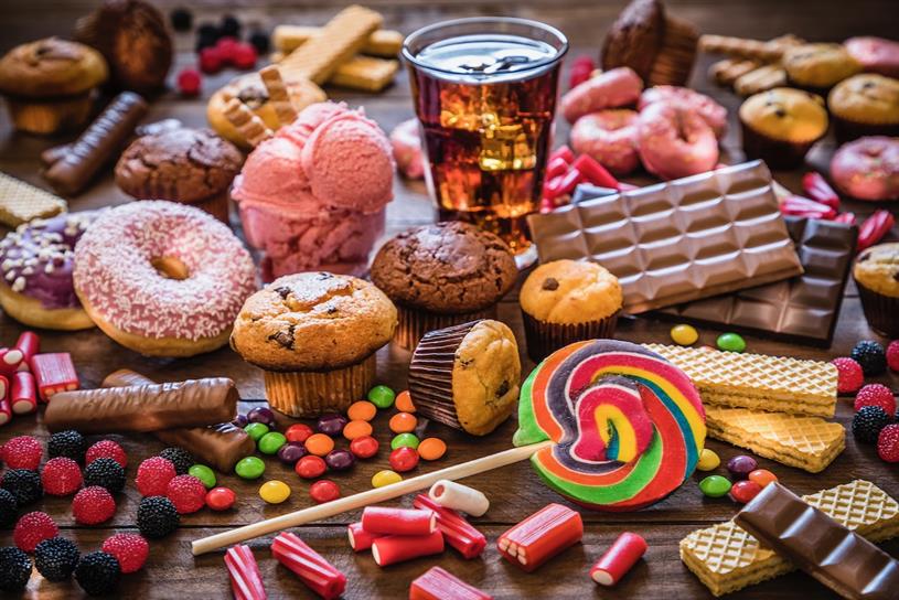 A picture of a table laden with foods and drink high in sugar