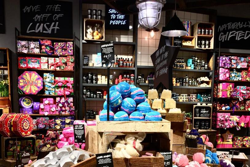 A picture of a Lush store, replete with brightly-hued pink, red and other primary coloured cosmetic products