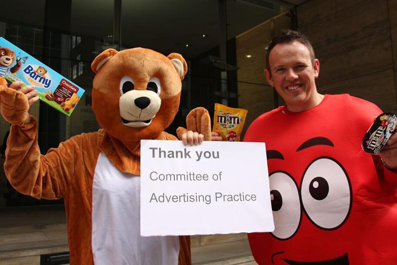 Protesters dressed as Barny, the Mondelez biscuit brand mascot, and Red, the leader of the M&M characters