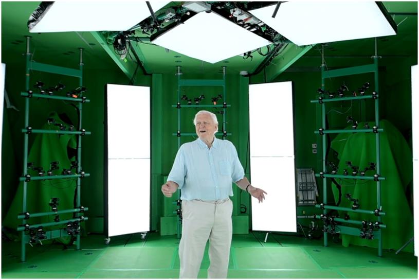 Sir David Attenborough stands in a green volumetric capture studio that contains multiple cameras 