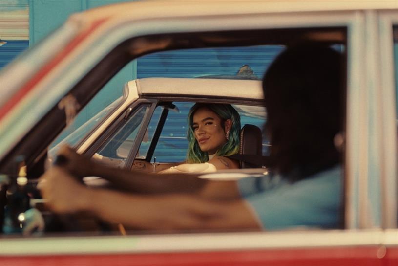 Karol G music video with Karol G  looking out a car window 