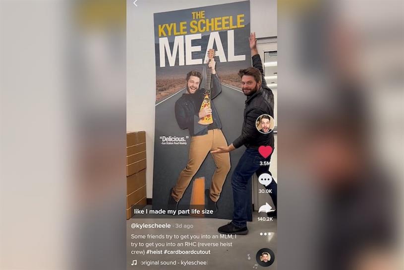 TikTok influencer Kyle Scheele standing with a cardboard cutout of himself.