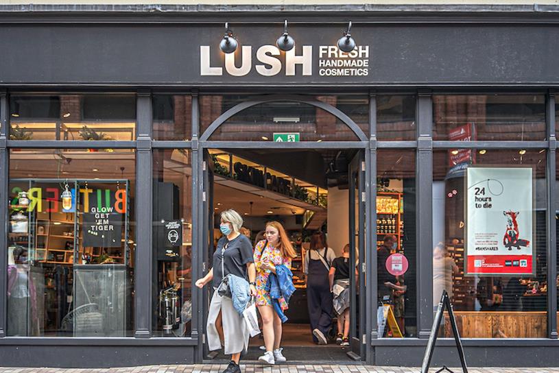 Two women outside a Lush cosmetics store front.