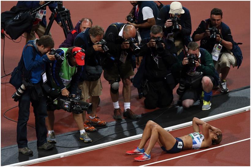 Jessica Ennis overlooked by photographers as she lies on the ground to celebrate her Olympic heptathlon gold 