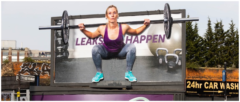 Billboard of woman squatting while weightlifting with real liquid dripping from between her legs