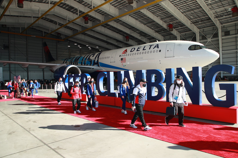 Team USA's Olympic team standing in front of a Delta jet