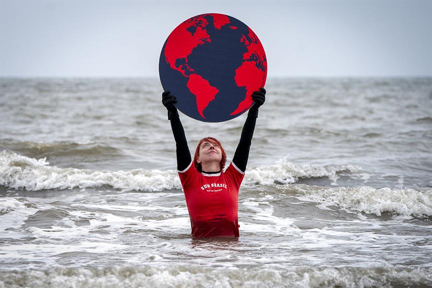 Susie Gray, from the Edinburgh Science Festival team, stands in the Firth of Forth at Portobello in Edinburgh, holding a giant black and red Earth to highlight the climate emergency and rising sea levels ahead of Earth Day on Friday April 22, 2022