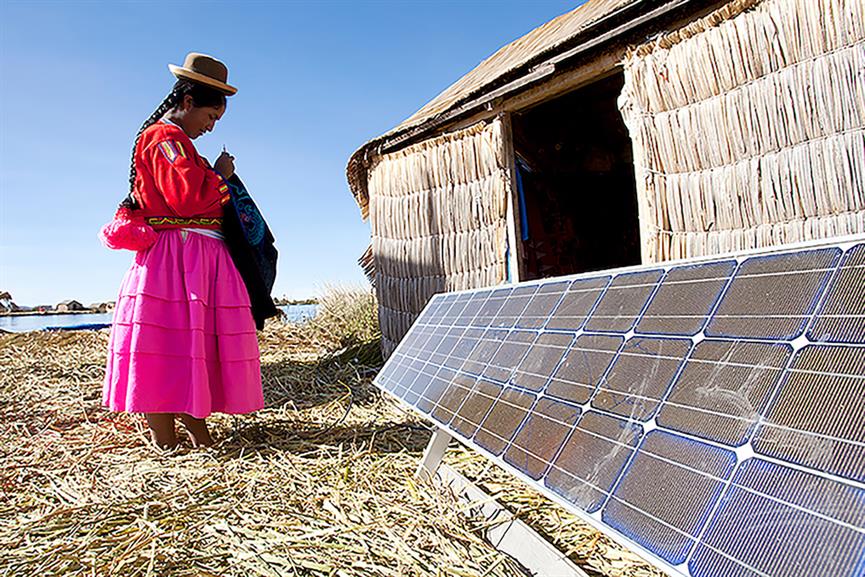 Woman standing in front of solar panels on rural home