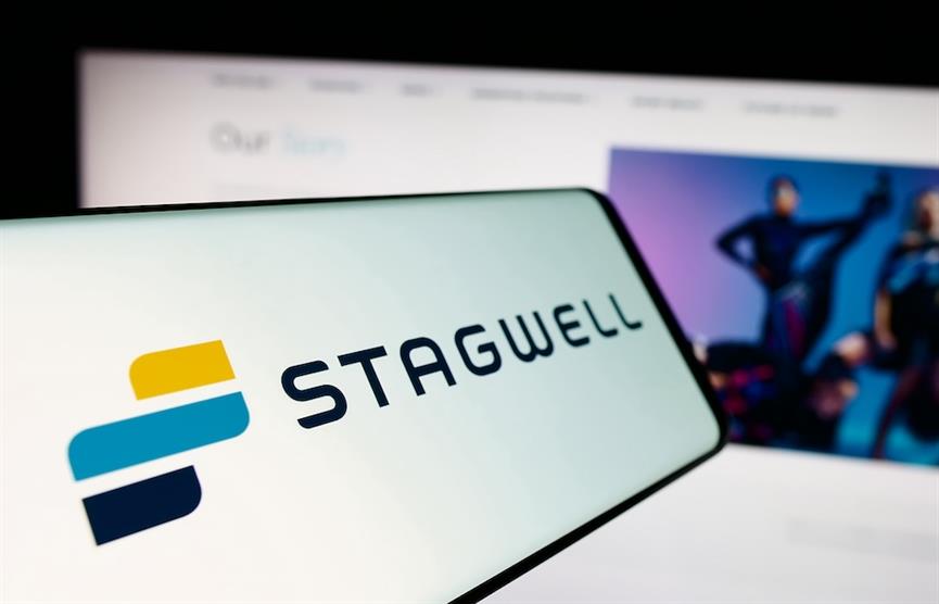 GERMANY - 2024/06/25: In this photo illustration, a mobile phone with the logo of American marketing and communications company Stagwell Inc. is seen in front of website.