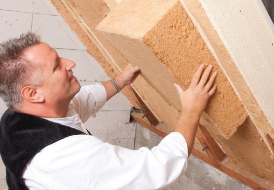 A worker installs Kronopoly made insulation