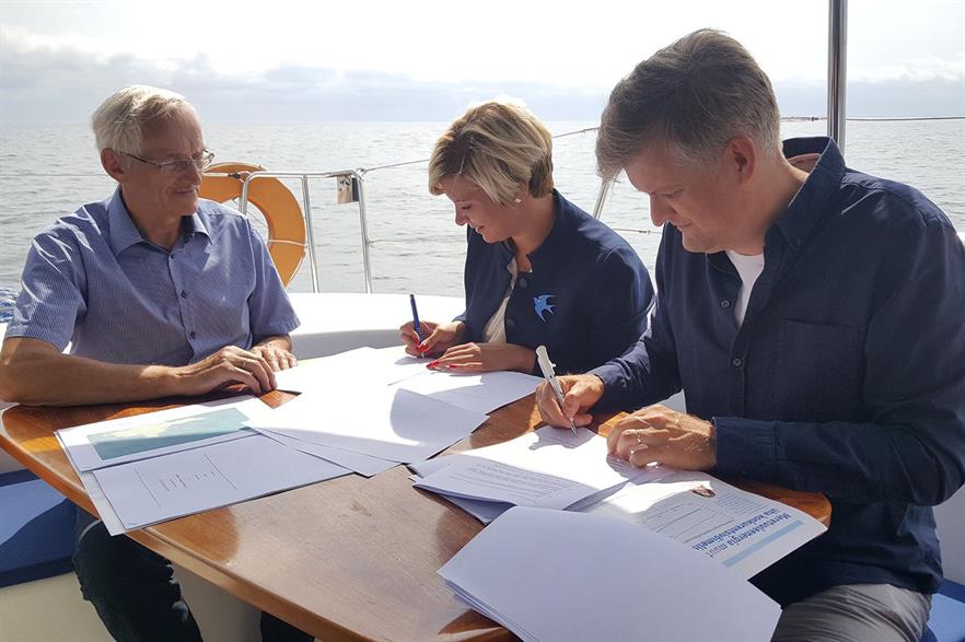 Mayor of Hiiu Reili Rand (centre) and Nelja Energia chairman Martin Kruus (right) sign the agreement