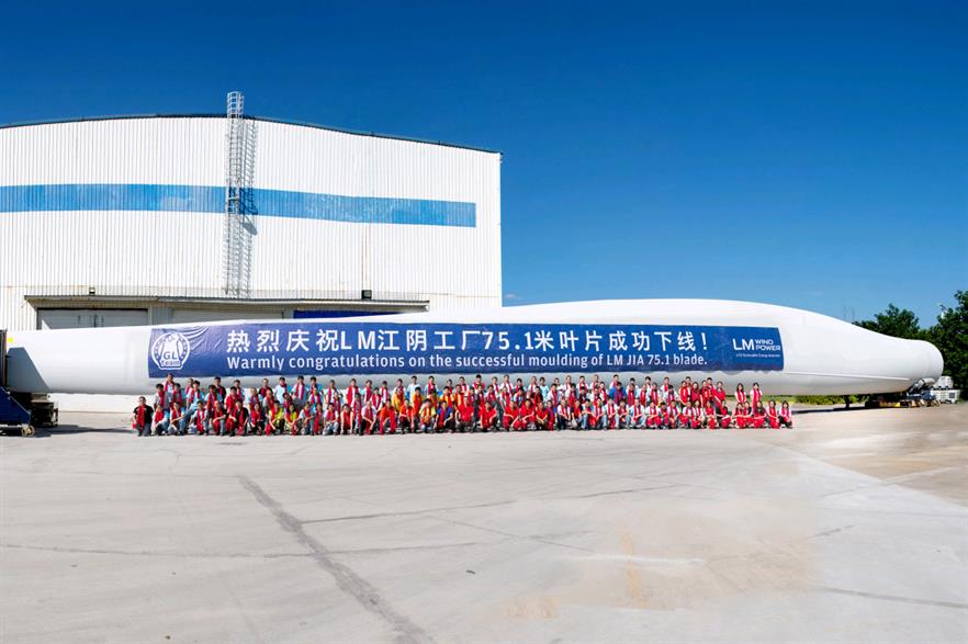 Workers celebrate the production of China's longest wind turbine blade