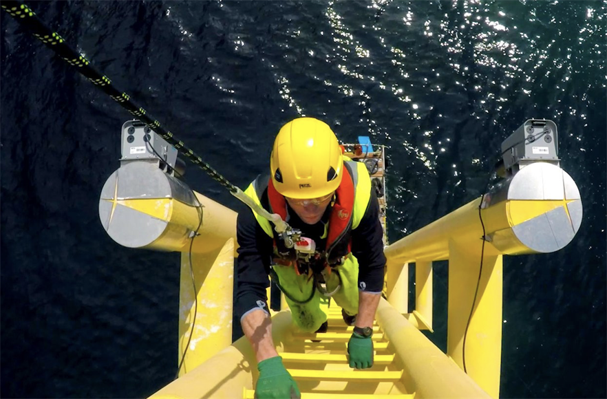 An engineer accessing an offshore wind turbine to carry out O&M activities