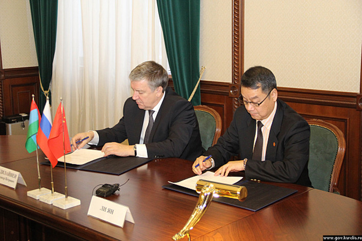 Head of the Karelia republic Alexander Khudilainen (left) and Sinomec's senior vice president Li Yang sign the agreement