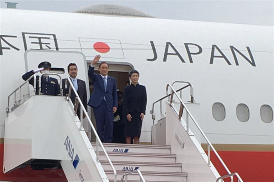 New Japanese head of state Yoshihide Suga disembarking a plane on his first foreign visit as prime minister