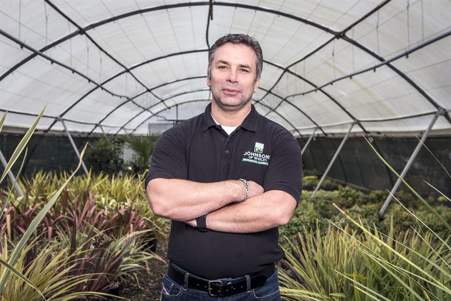 Graham Richardson, group managing director at Johnsons of Whixley, standing surrounded by plants in a polytunnel