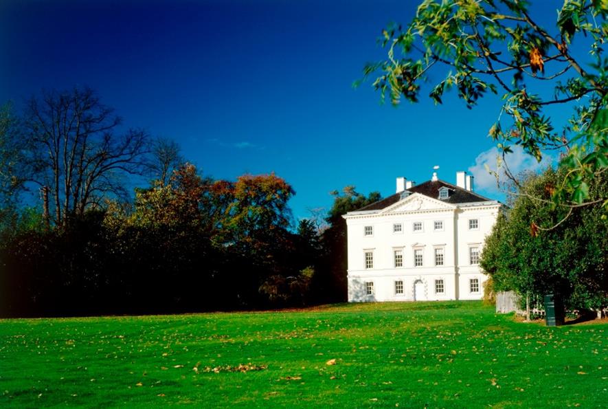 White house and extensive lawn bordered by trees at Marble Hill