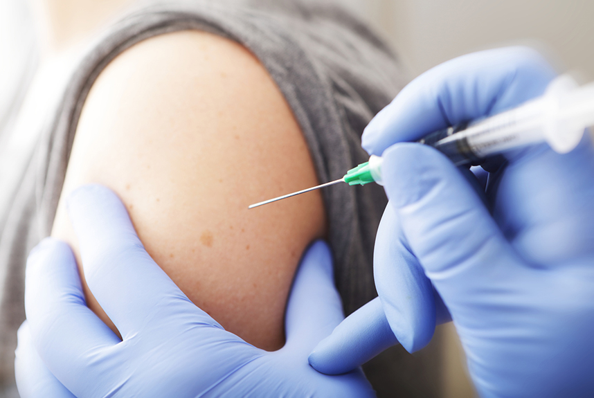 Close up of an arm with flu jab about to be injected
