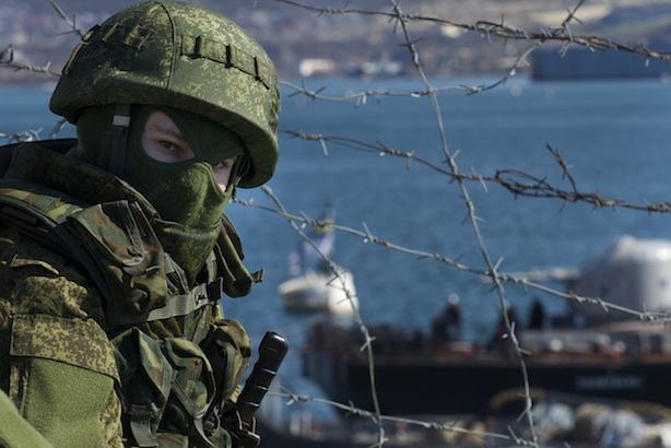 Tensions: Russian soldiers guard a pier where two Ukrainian naval ships are moored, in Sevastopol, Ukraine, on Wednesday, March 5, 2014 (AP Photo/Andrew Lubimov)