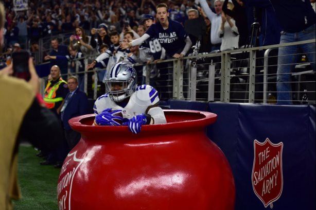 Ezekiel Elliott jumps into the Salvation Army's Red Kettle, bringing with him a 61% increase in online donations. (Image via the Salvation Army’s Twitter account). 