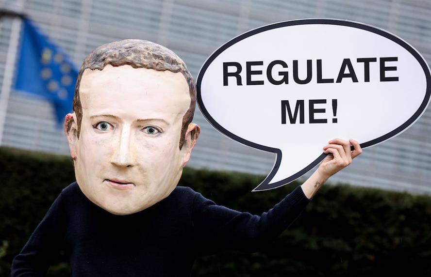A mask-wearing activist depicting Facebook CEO Mark Zuckerberg outside the European Commission in Brussels last December. (Credit: Getty Images)