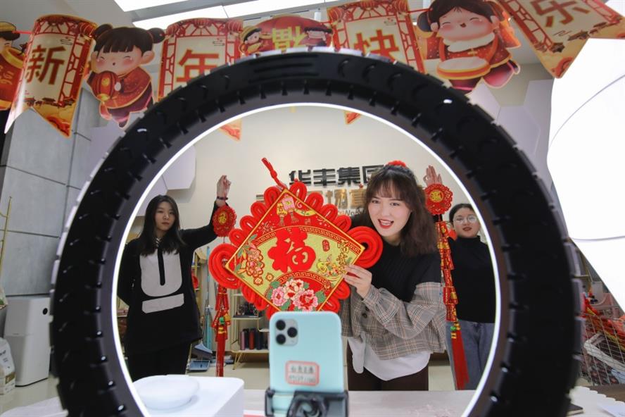 A livestreamer sells CNY decorations on a smartphone in Linyi, Shandong Province of China. (Getty Images)