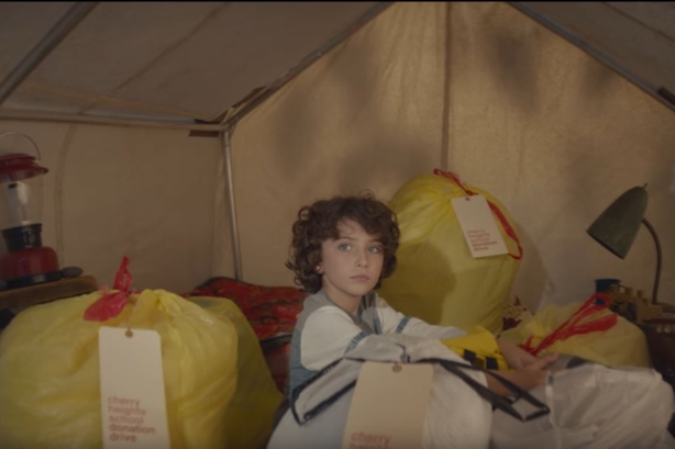 The anthem video tells the story of a boy giving away his personal possessions to charity. (Image via YouTube).