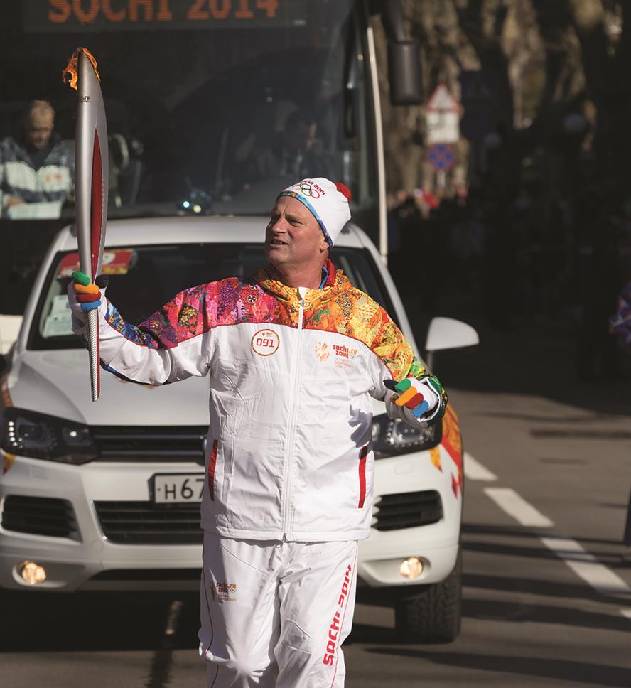 Jon Tibbs, chairman and founder of JTA, runs with the Olympic torch through the streets of Sochi