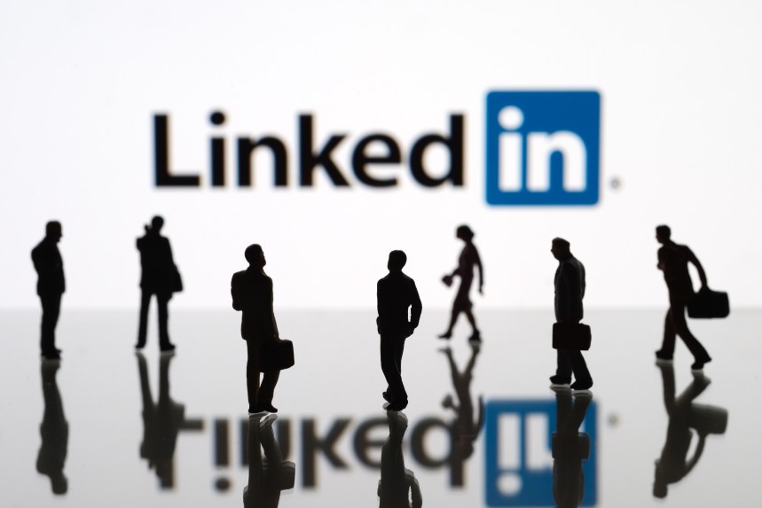         LinkedIn logo with silhouettes of businesspeople in front of it