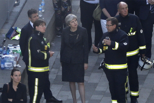 Theresa May meets firefighters as she visits Grenfell Tower (Credit: TOLGA AKMEN/AFP/Getty Images)